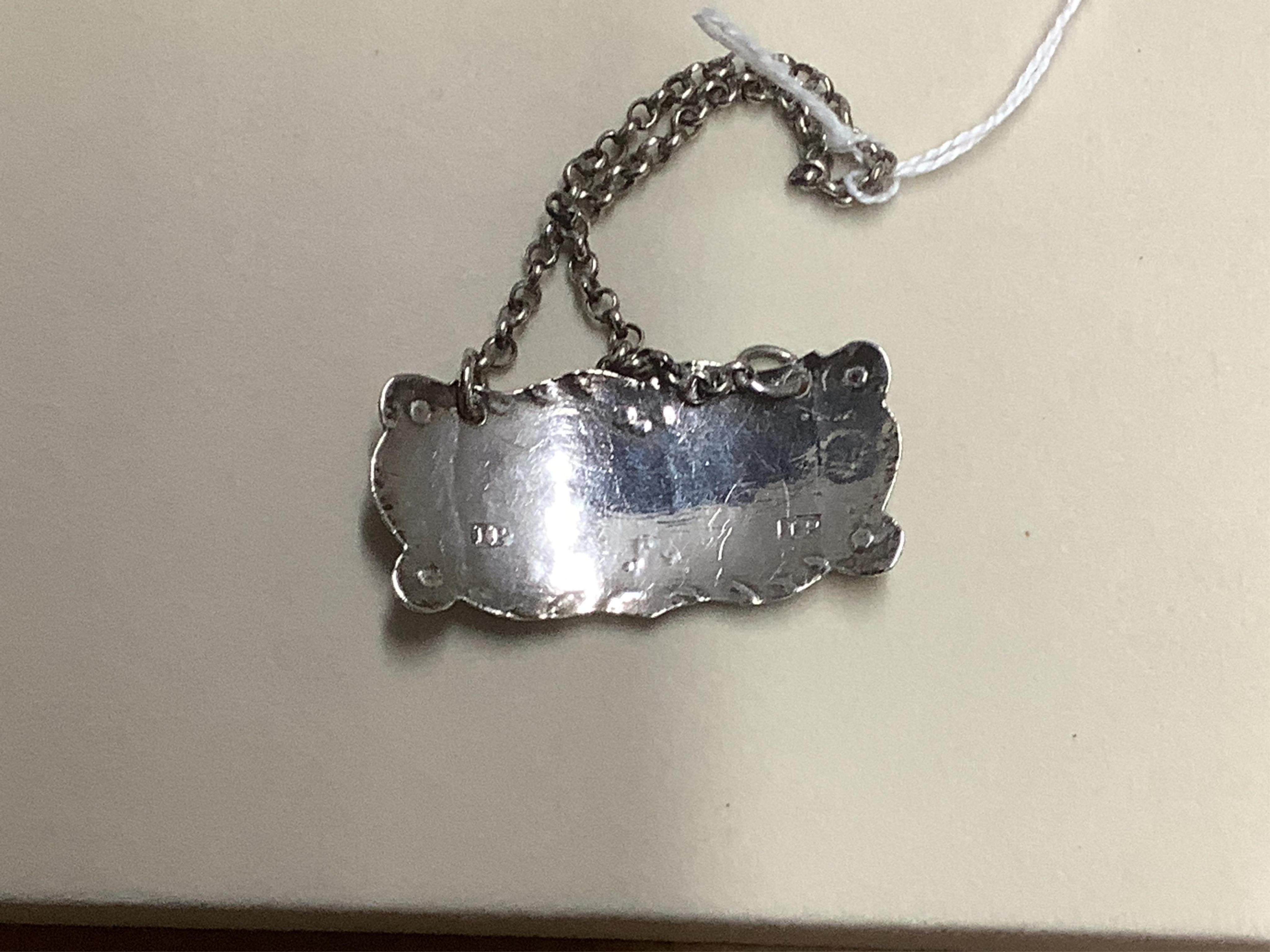 Four silver napkin rings including a pair, Sheffield, 1919, together with two George III silver wine labels, Claret, maker probably Abstinando King and Port, maker James Phipps I.